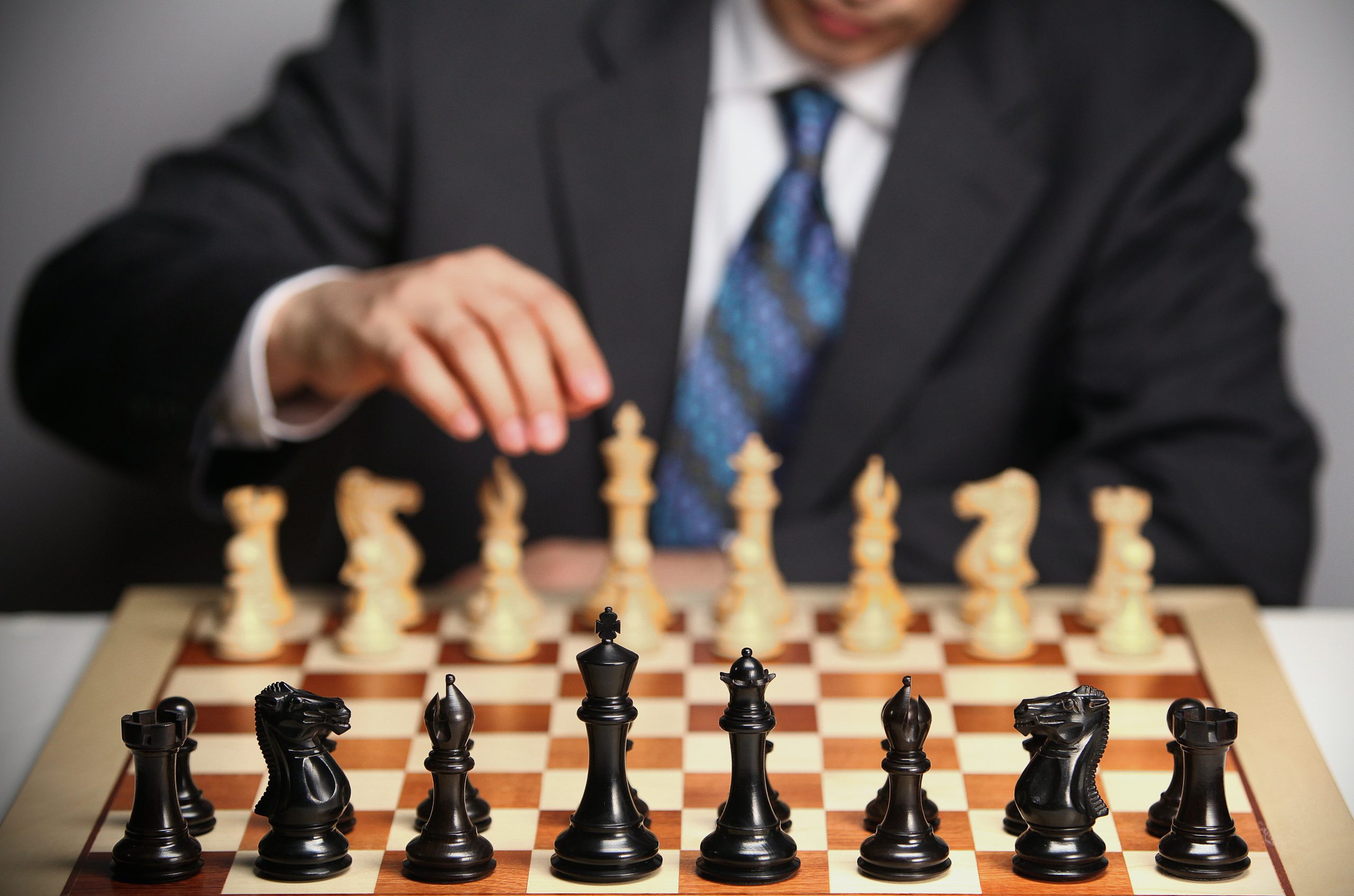 man in suit playing chess