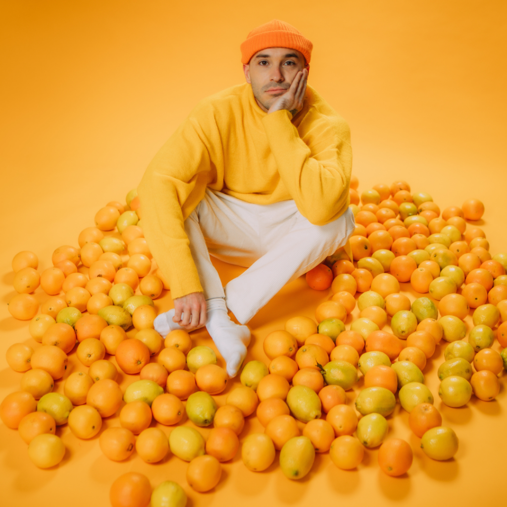 man sitting in orange room with oranges