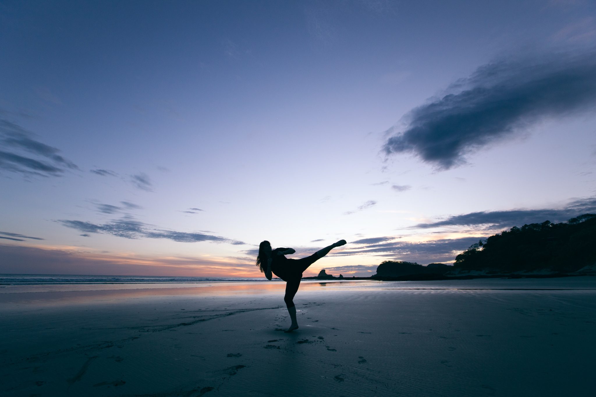 woman practicing martial arts on a beach