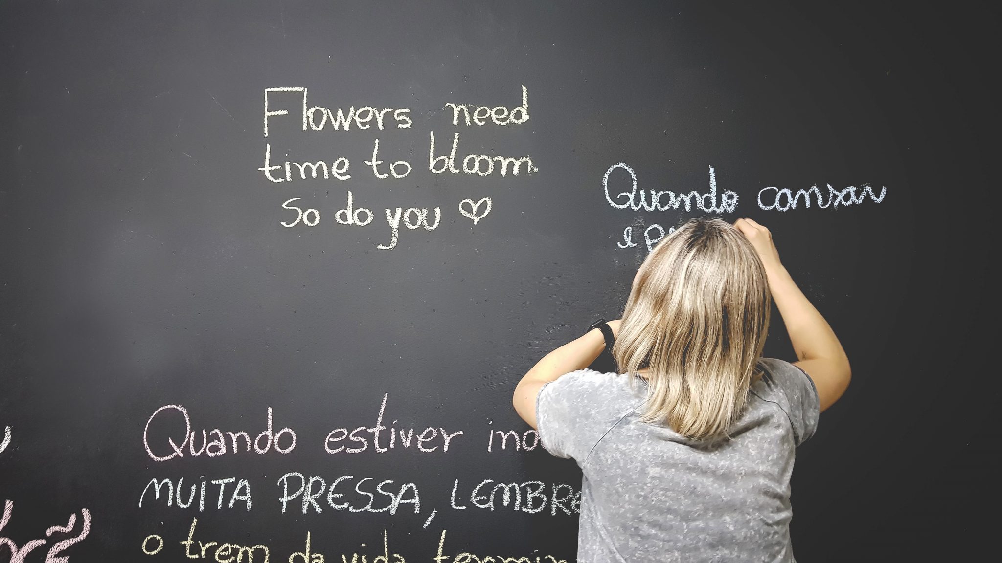 woman writing on chalkboard in spanish