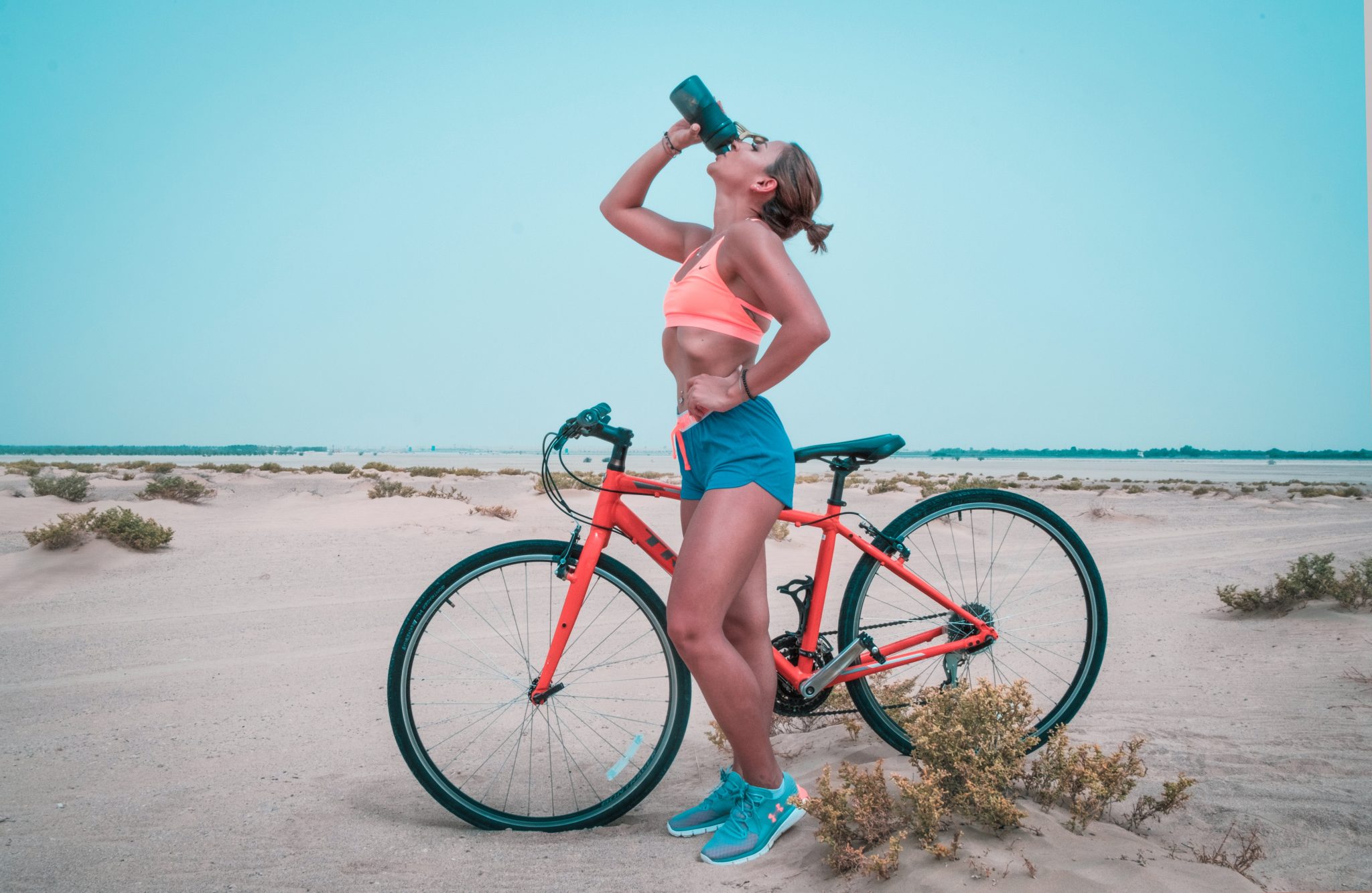 woman drinking water with bike