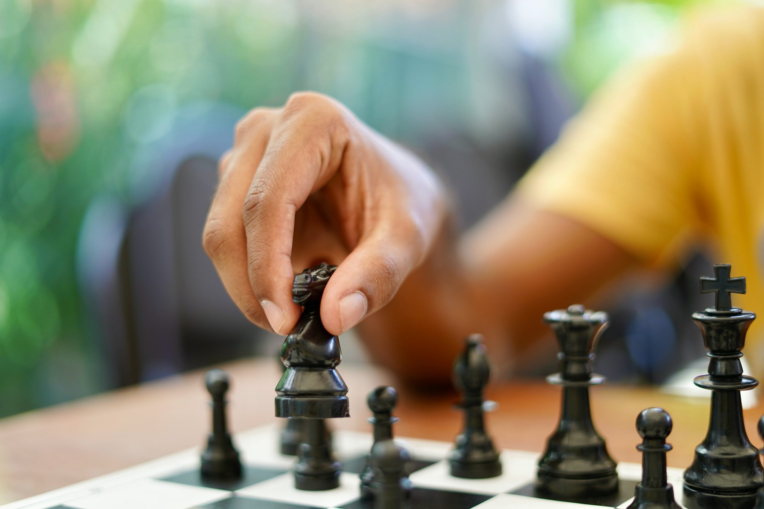 Concept: the woman who dominates the man. A woman's hand gives checkmate to  the king with the queen on a wooden chessboard, with no other pieces in  play Stock Photo