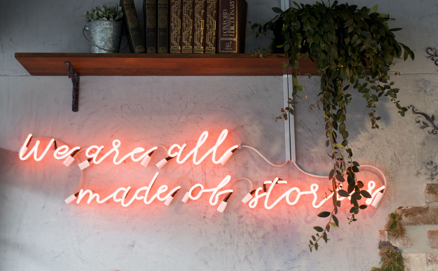 "We are all made of stories" on pink neon sign