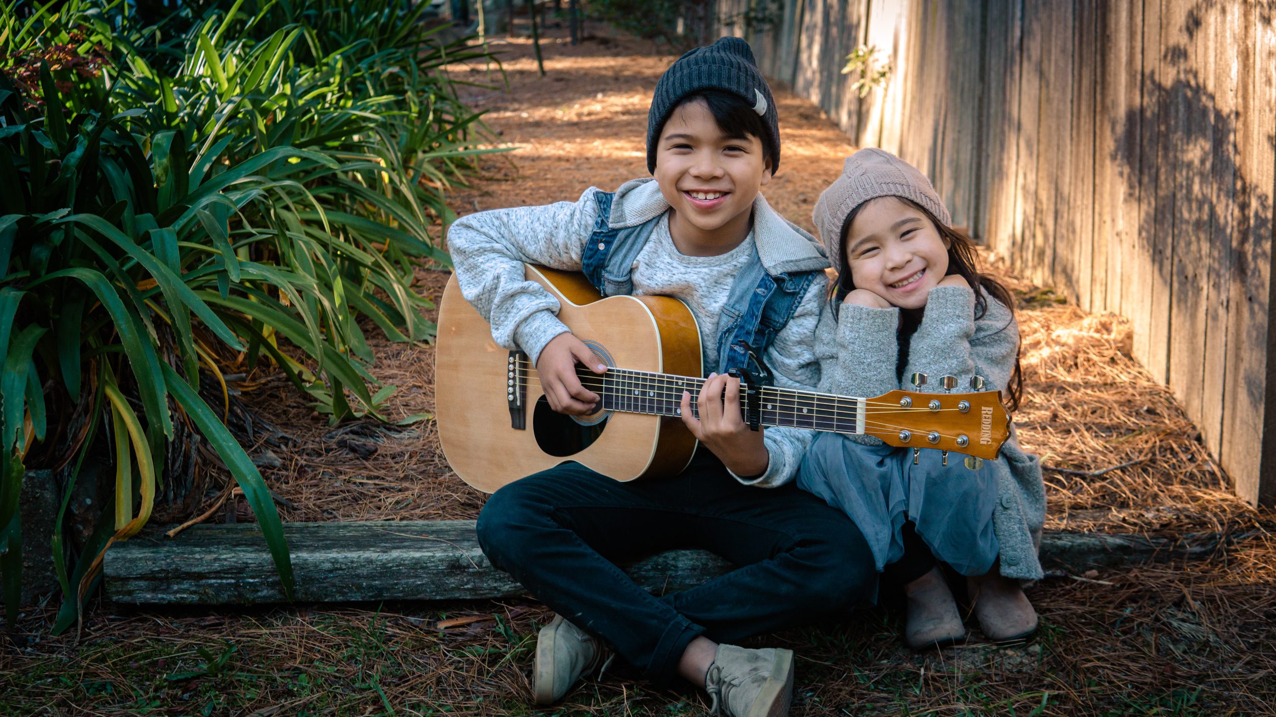 kids smiling with guitar