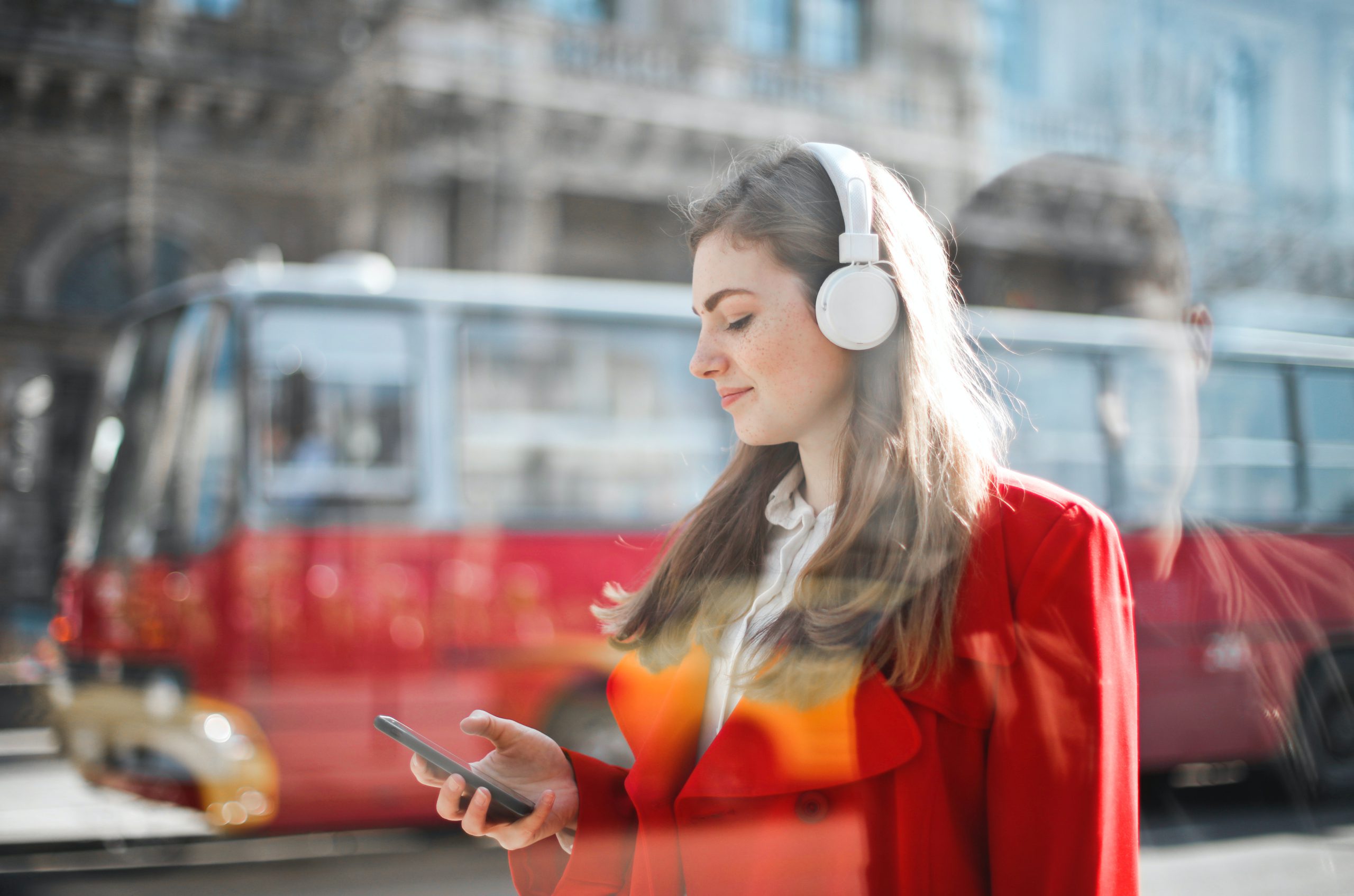 woman with headphones checking phone