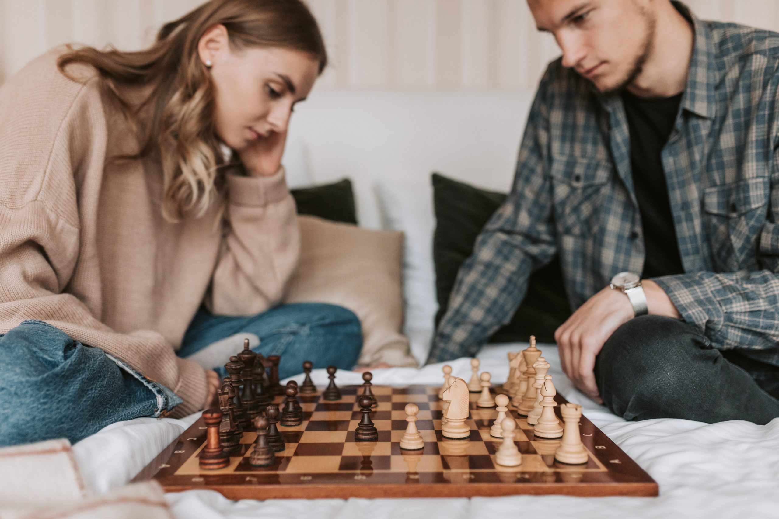 man and woman playing chess