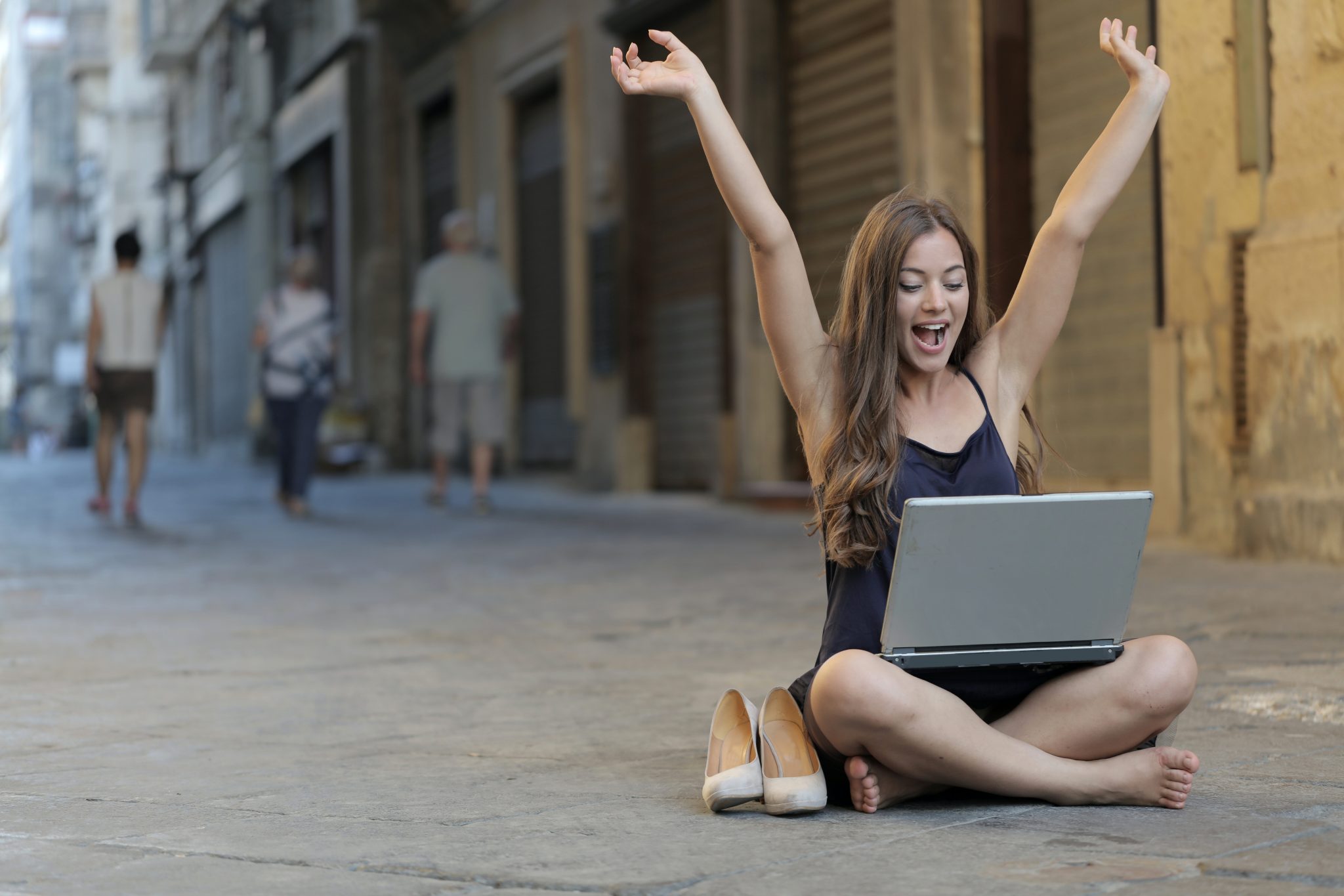 woman happy with laptop on the street