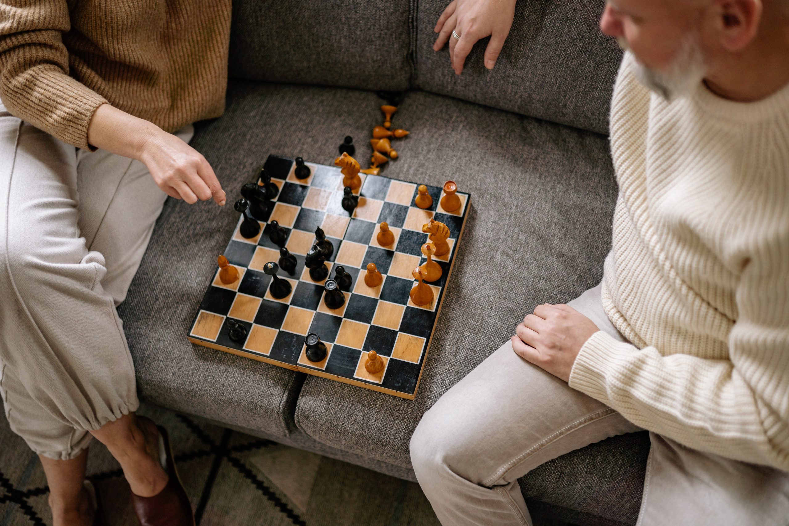 two people playing chess on a couch