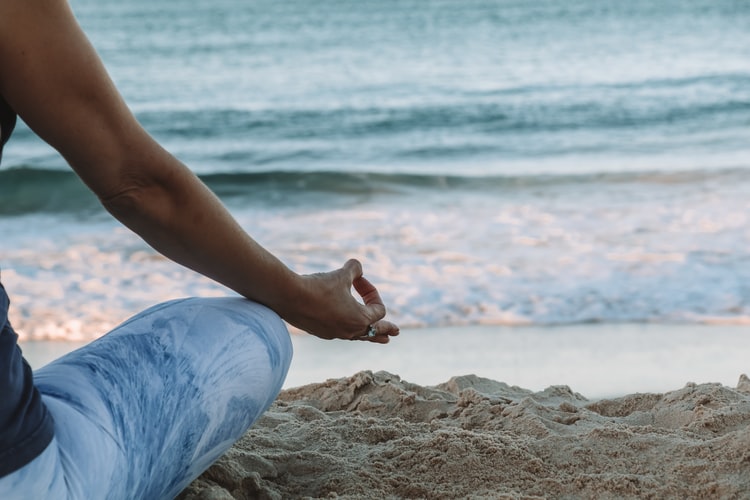 person meditating on beach Amphy