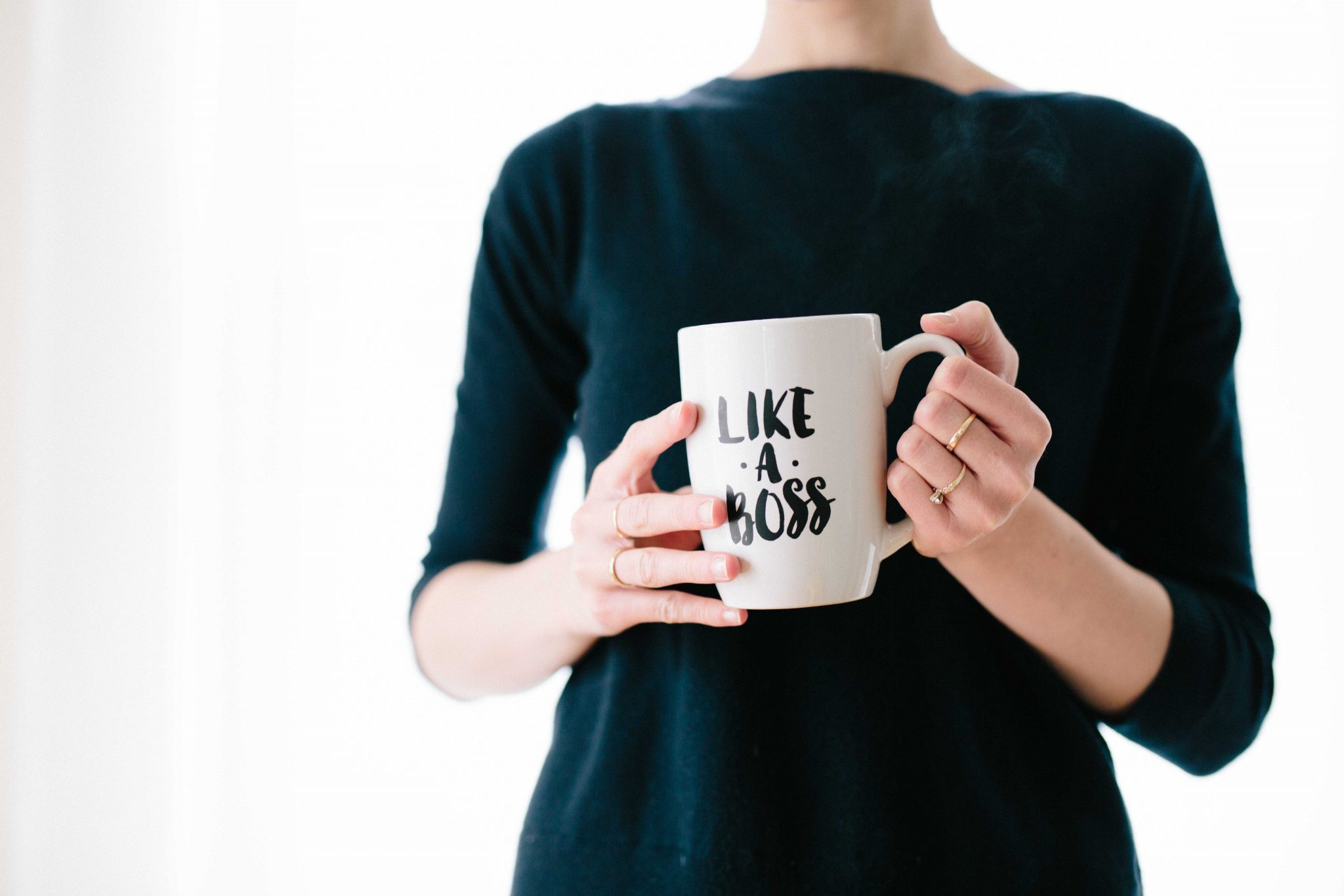 woman holding a mug that reads 'like a boss'
