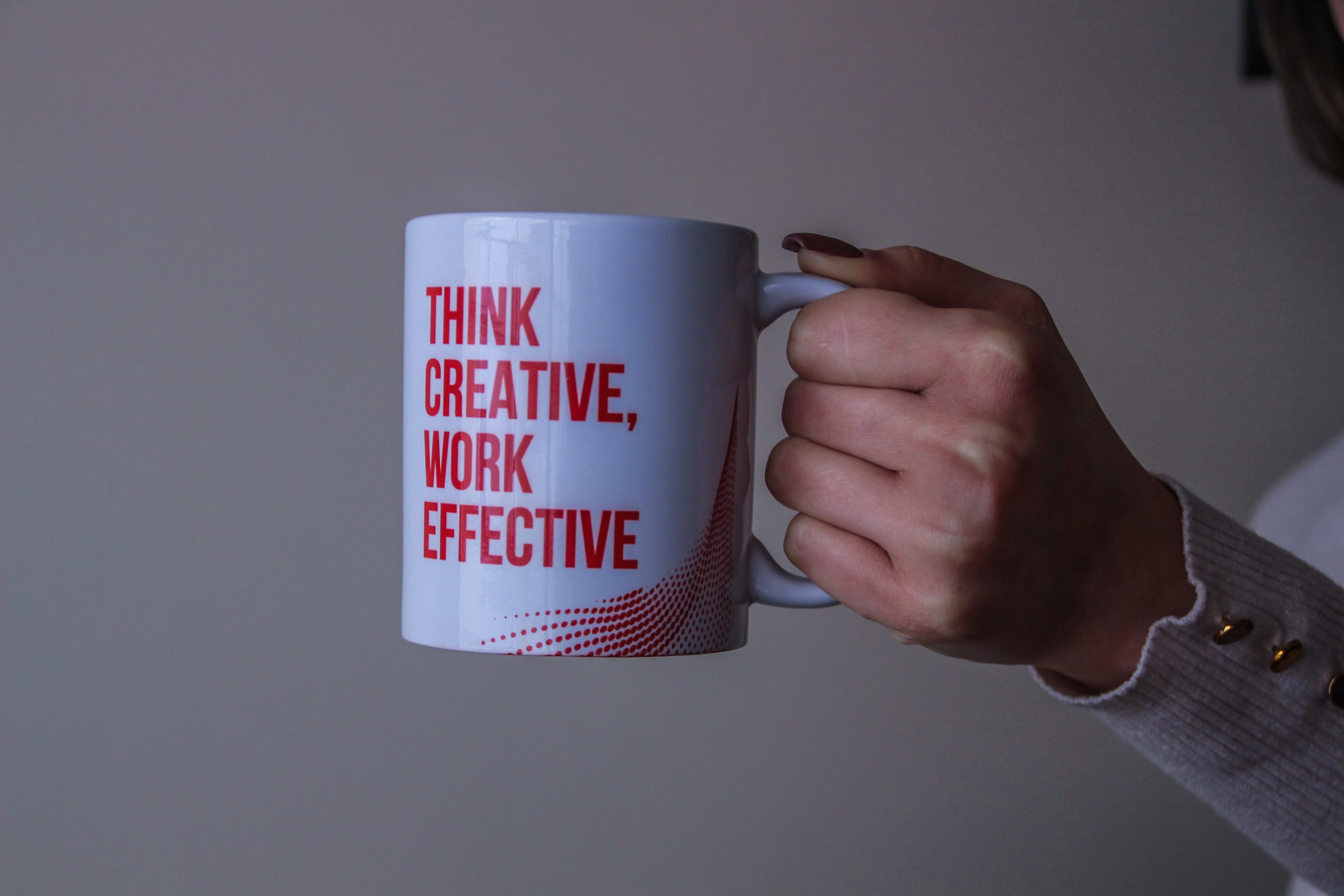 white mug with red text that reads 'Think creative work effective: