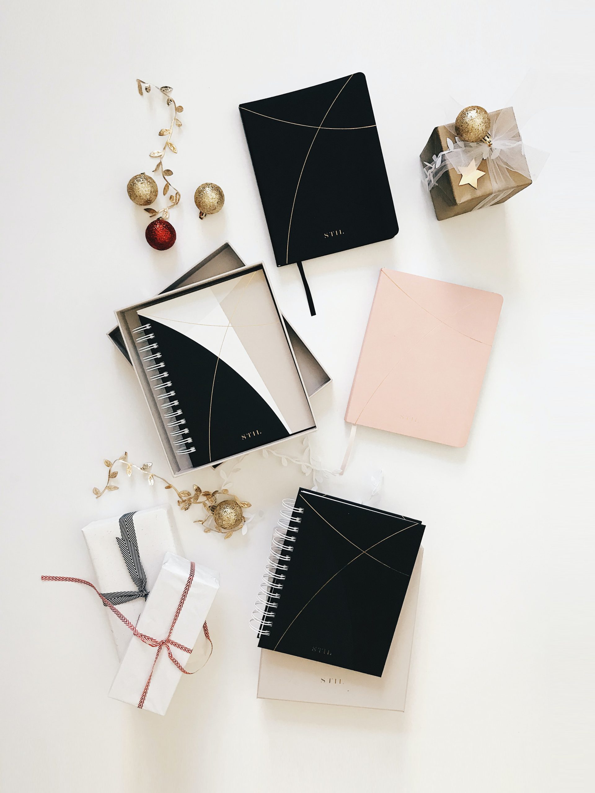 presents and notebooks displayed on a white table