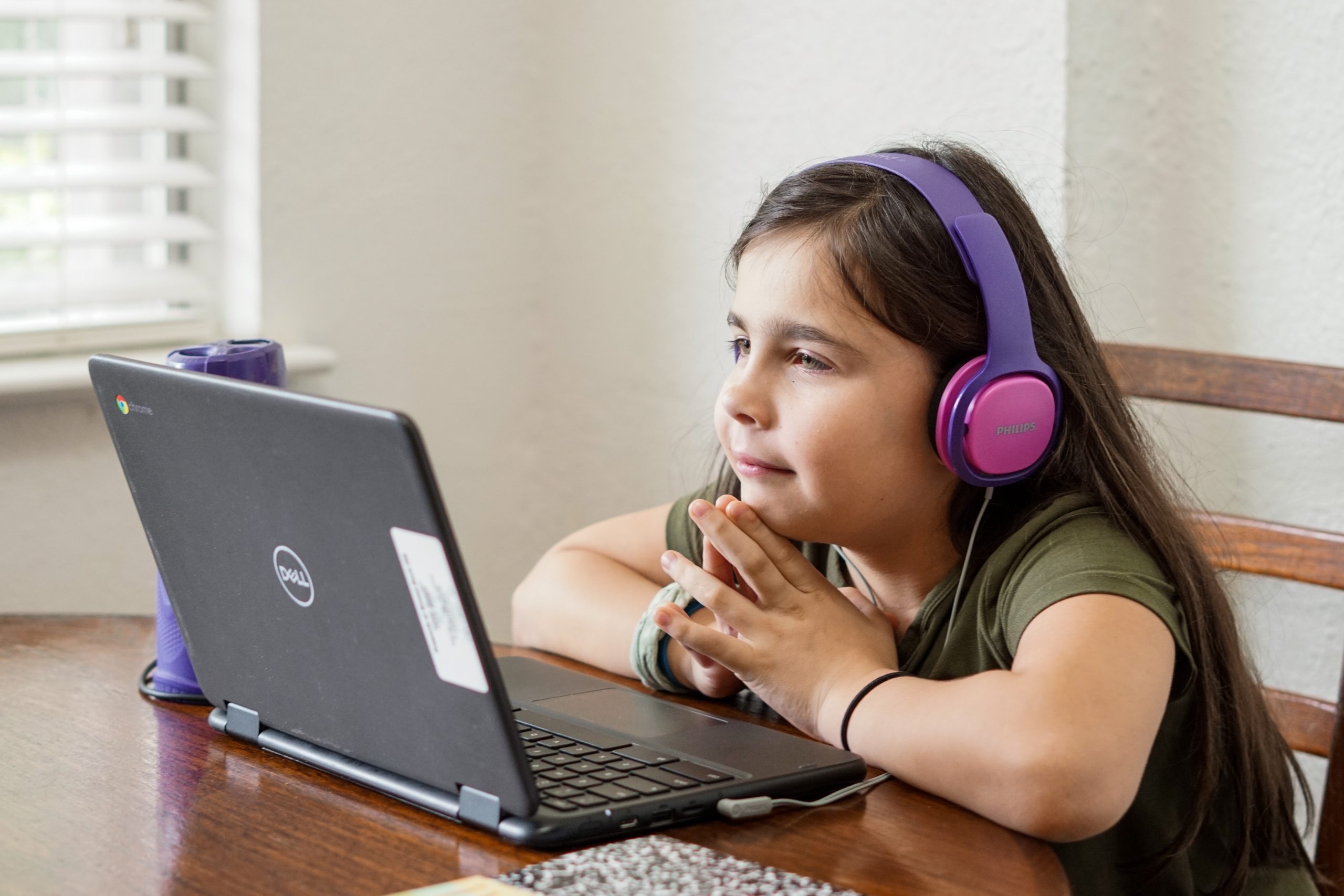 child wearing headphones in front of laptop