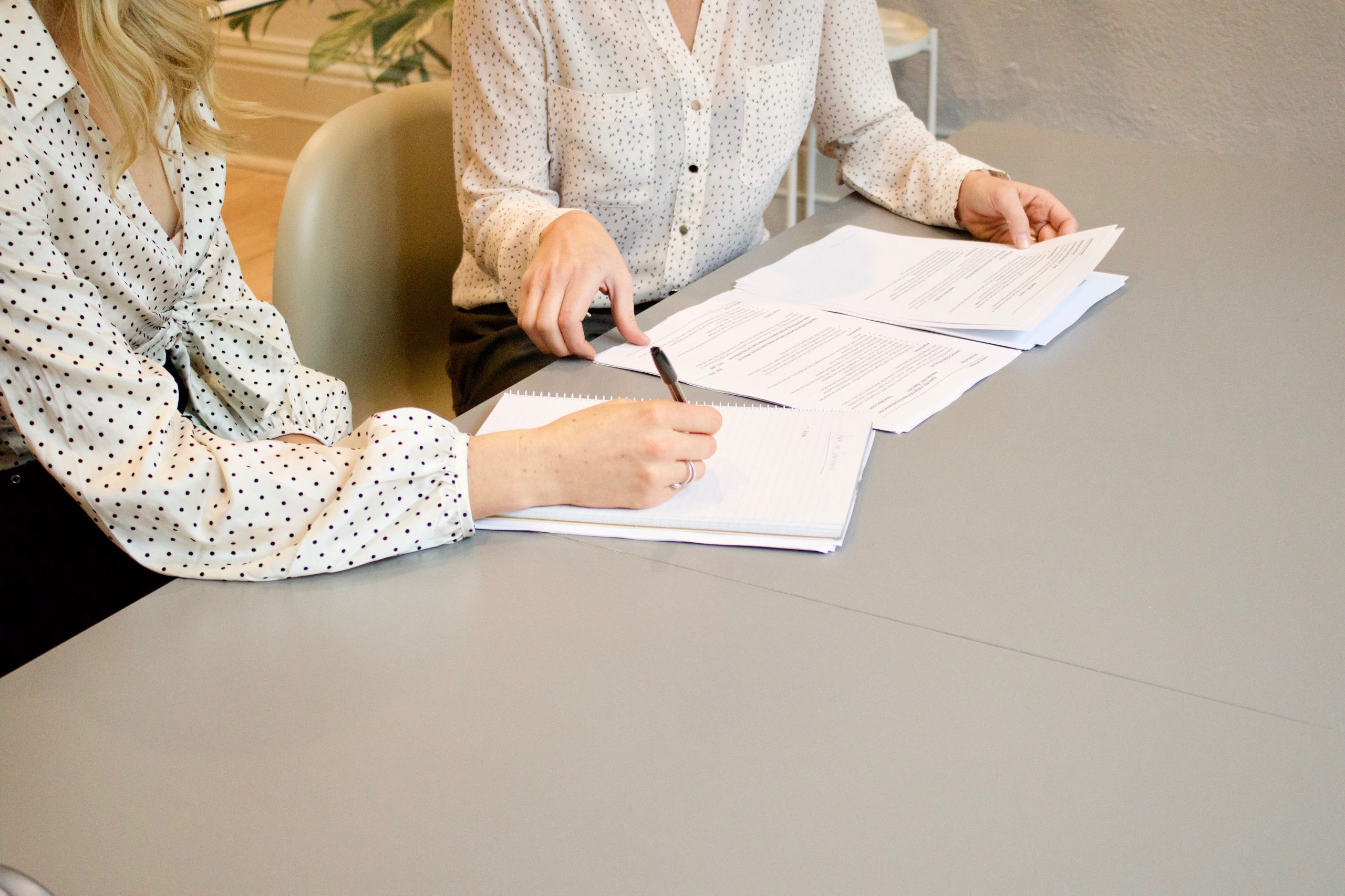 two women signing a contract