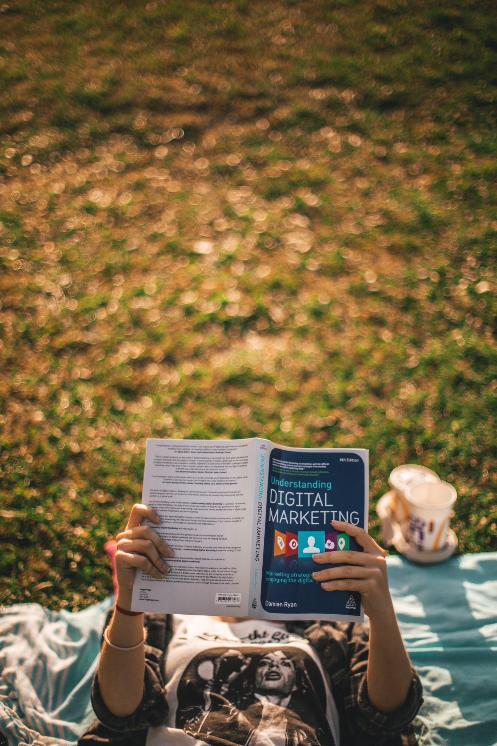 person lying down reading a book about digital marketing