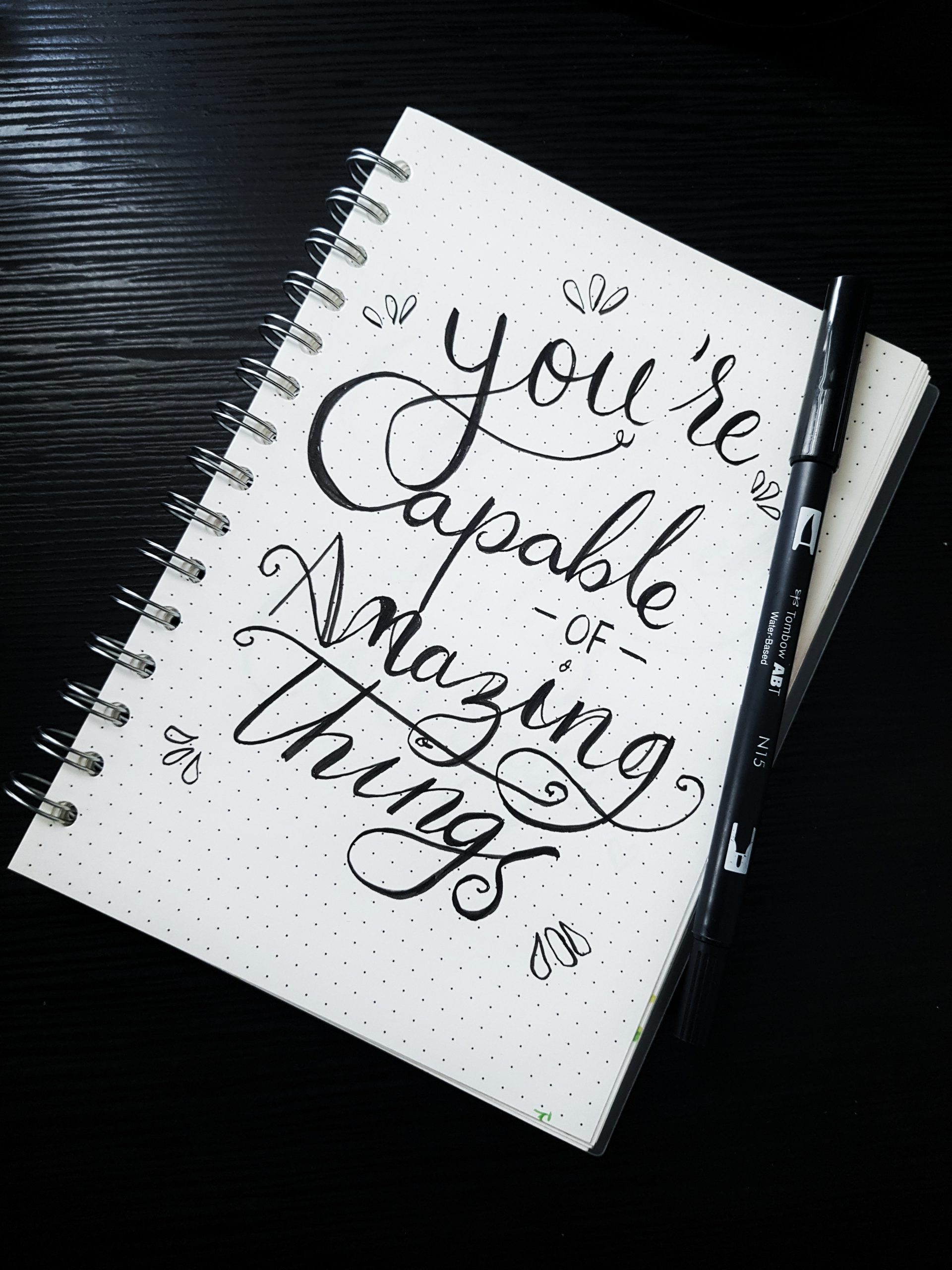 notebook with writing that says 'you are capable of amazing things'