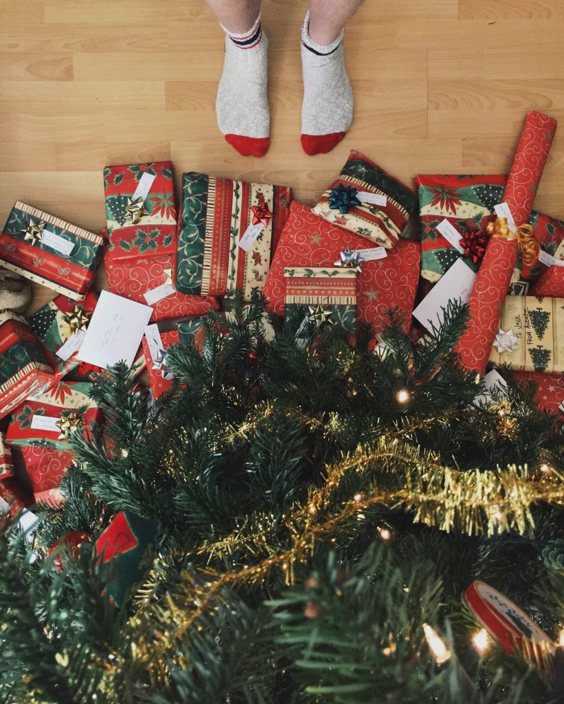feet standing at a pile of presents