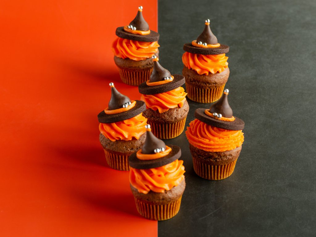 cupcakes decorated like witches with black and orange background