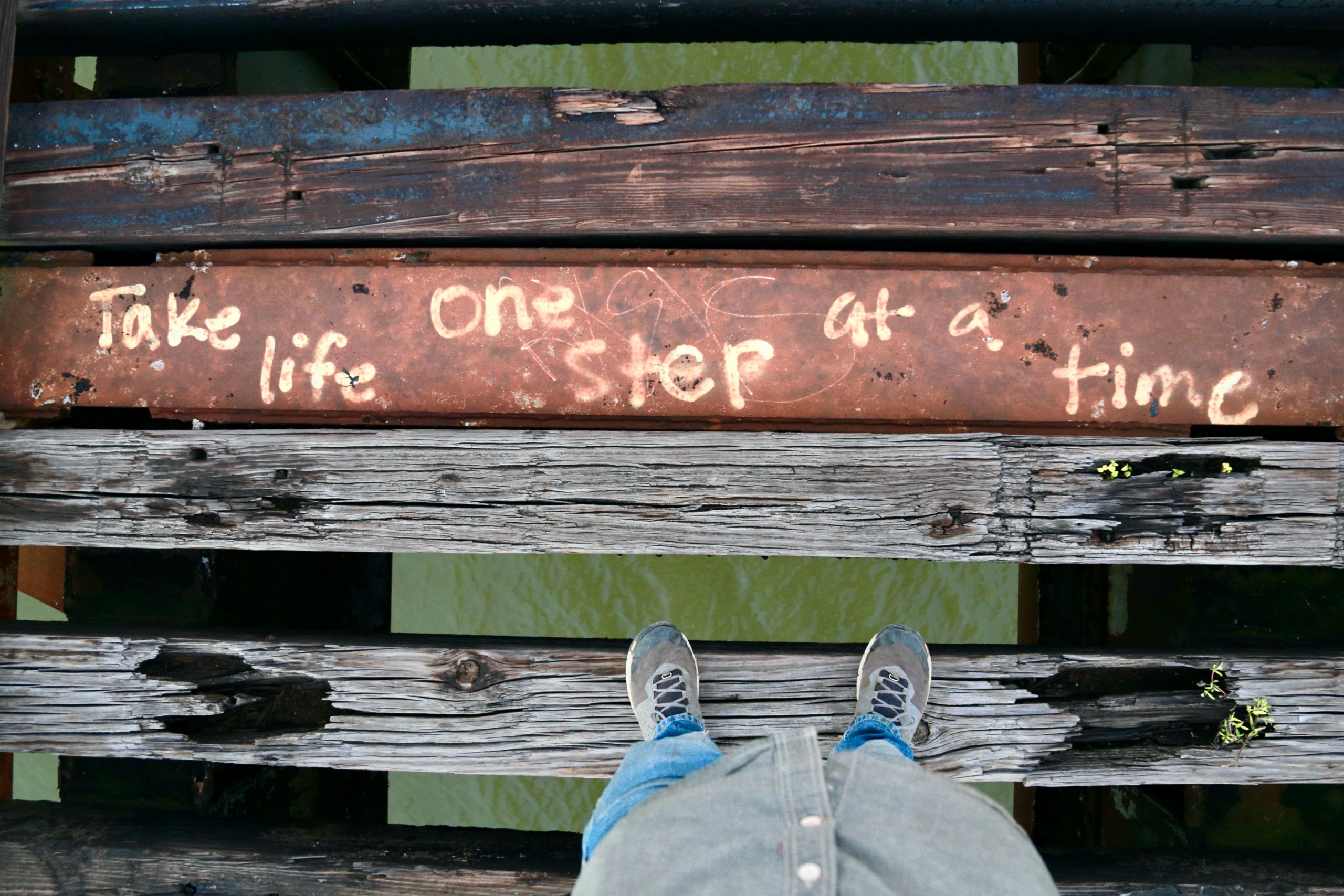 wooden plank that reads "take life one step at a time"