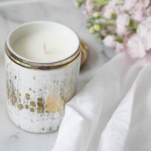 white candle in a white and gold jar