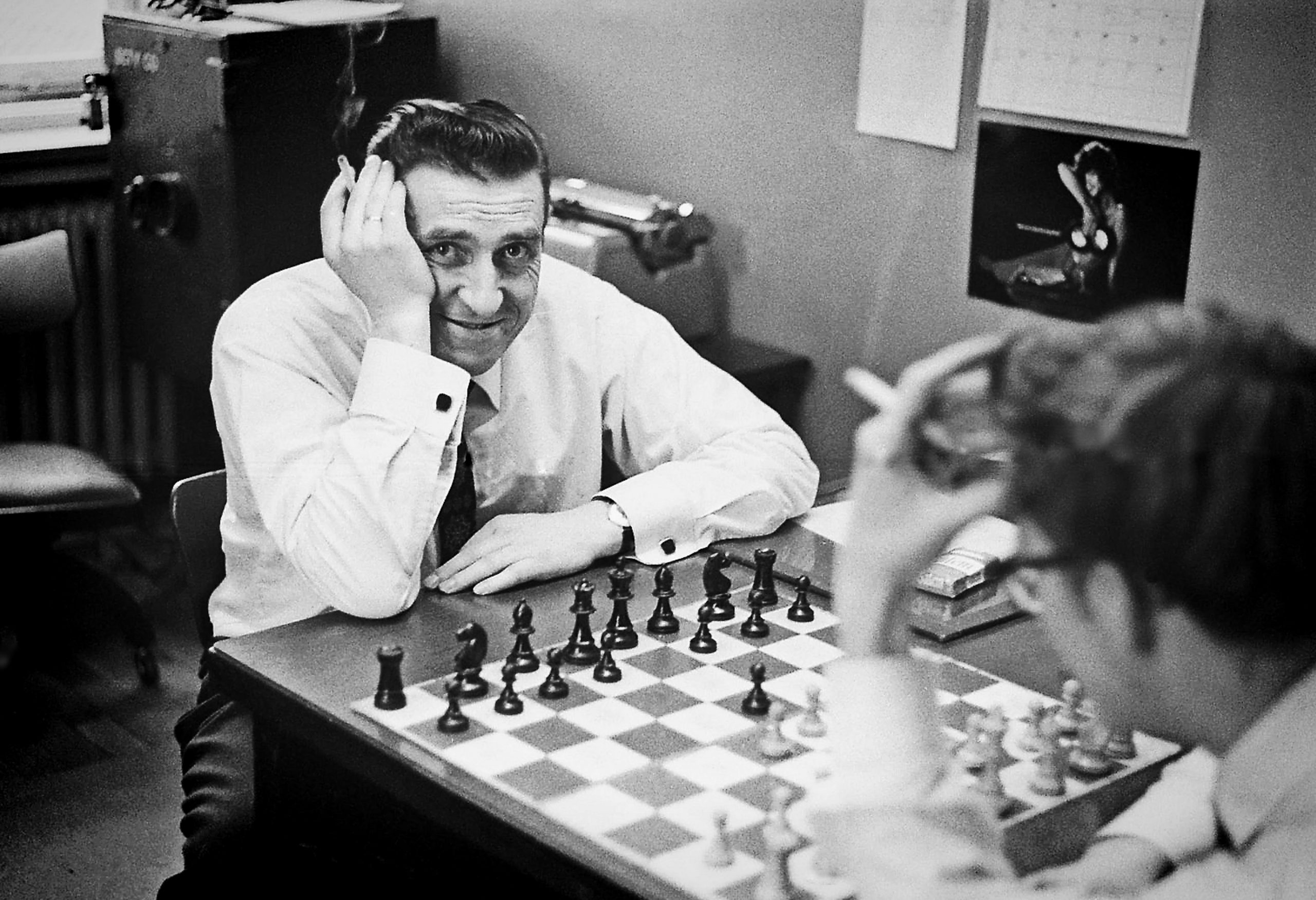 black and white photo of a man playing chess